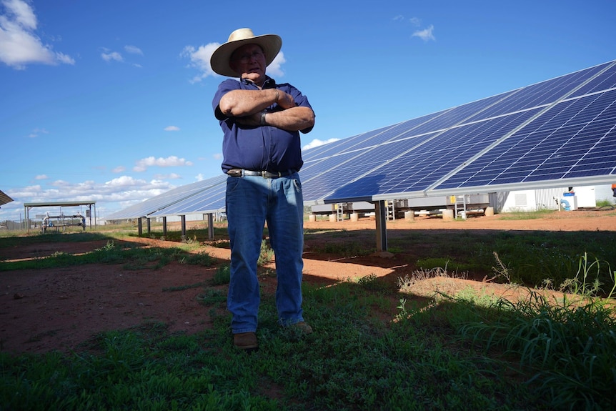  A man standing near solar panels in Thargomindah