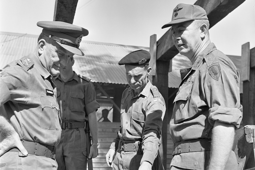 A black and white photo of four men wearing military uniforms.