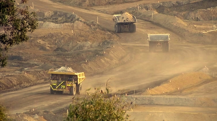 Haul trucks on a dusty mine road