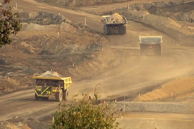 Haul trucks on a dusty mine road