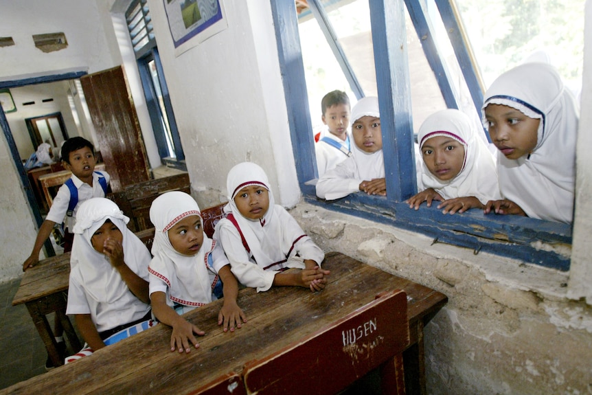 Le ragazze indonesiane aspettano a scuola l'inizio delle lezioni il primo giorno di scuola dopo il devastante disastro dello tsunami.