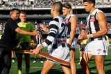 St Kilda and Collingwood players stand alongside Nicky Winmar in the centre circle before an AFL game