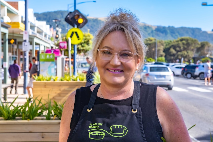 A woman in the main street of a coastal town with cars and pedestrians in the background 20/01/2021