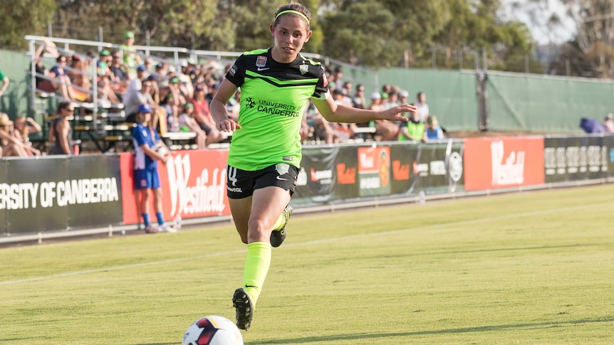 Ash Sykes dribbles the ball for Canberra United