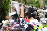 People clearing out flood-damaged items from homes in Townsville