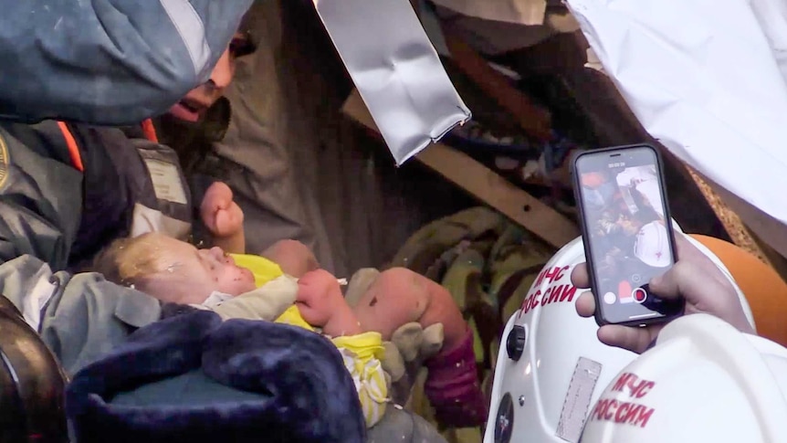 Rescue workers pull baby boy from rubble