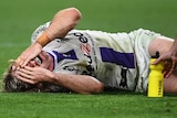 A Melbourne Storm NRL player lies in agony holding his face after sustaining a leg injury.