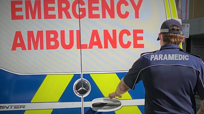Ambulance Tasmania paramedic at rear of vehicle.