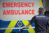 Ambulance Tasmania paramedic at rear of vehicle.