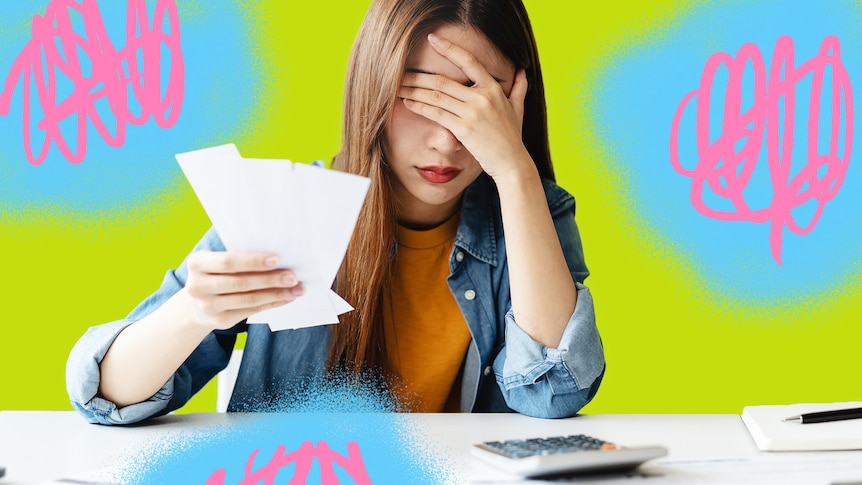 A woman holds her head while holding receipts. A calculator is in front of her.
