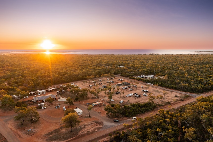 An aerial shot of an Indigenous community with the sun setting in the background.