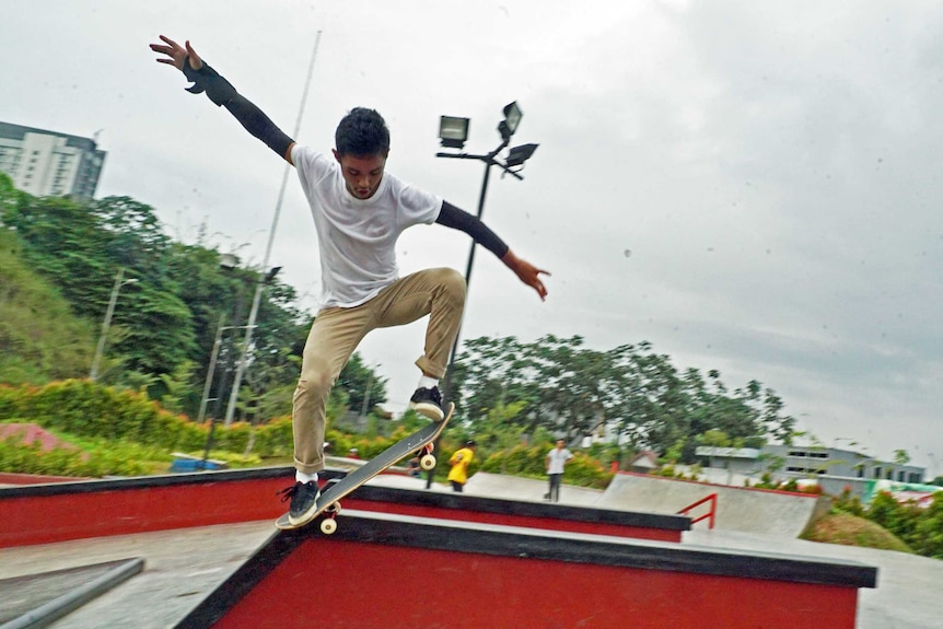 Indonesian skater Muhammad Fachrell Arshaffa Putra does a trick on a raised platform at the skatepark.