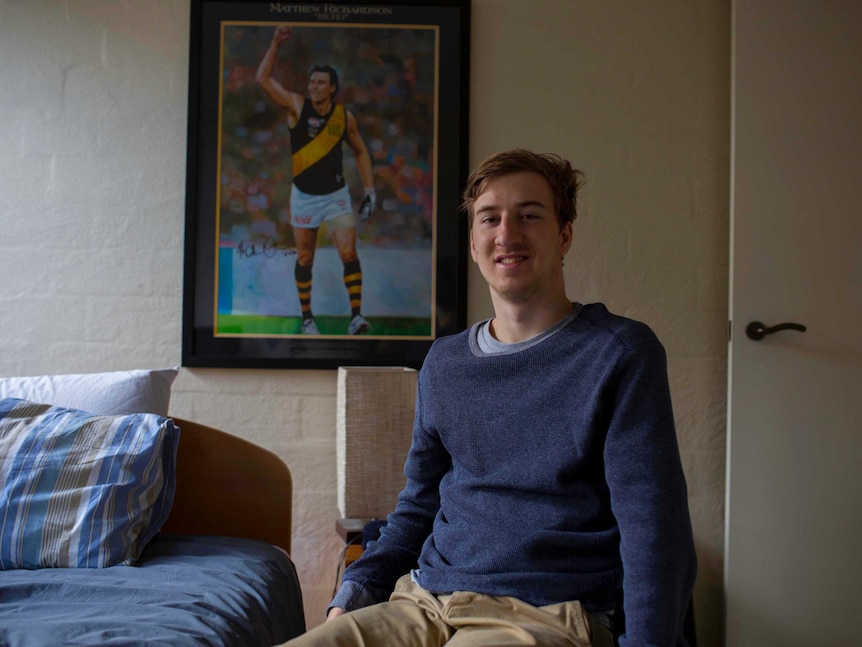 Jack Vawdrey in his bedroom in front of a poster of his favourite Richmond player, Matthew Richardson