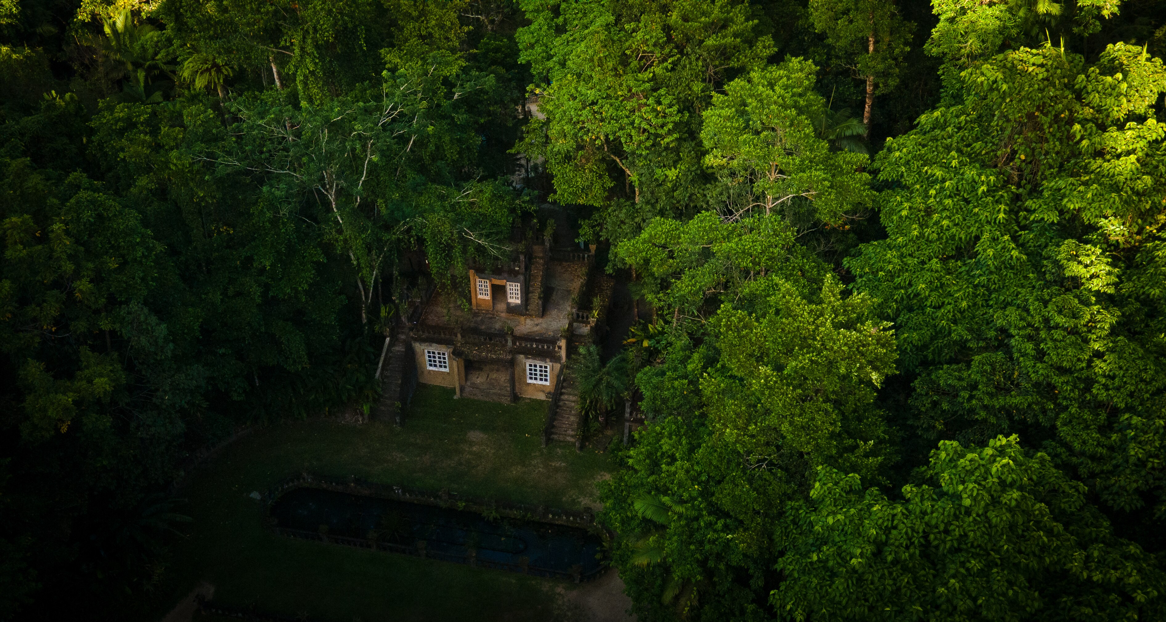 Una toma de un dron de un castillo dentro de una selva tropical.