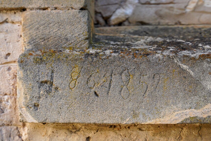 The date 1857 scratched into an old block of stone.
