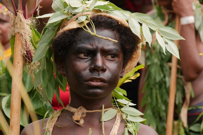 A Manus Island boy in traditional dress to welcome former ABC correspondent Sean Dorney.