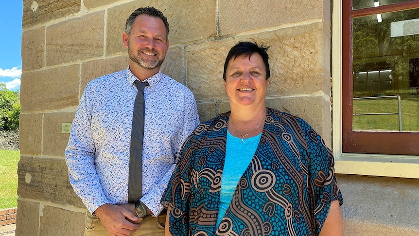 Director of Aboriginal Campuses for Barker College Jamie Shackleton and teacher Mandy Shaw stand outside a sandstone building