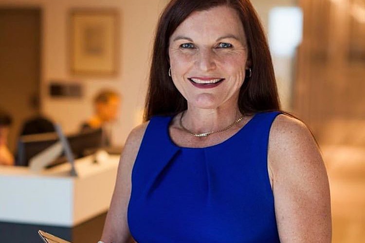 Annie Gibbins smiling and holding a notepad.