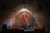A woman removes bricks from inside a kiln in Cambodia.