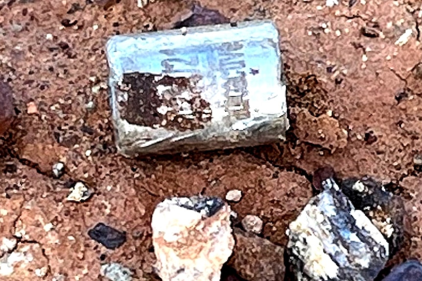 A metal capsule in dirt