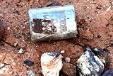 A metal capsule in dirt
