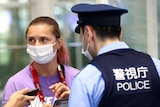 Close up of Belarusian sprinter Krystsina Tsimanouskaya speaking to police at the airport.