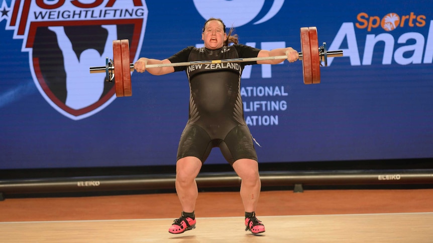 Laurel Hubbard heaves the bar upwards during a weightlifting competition.