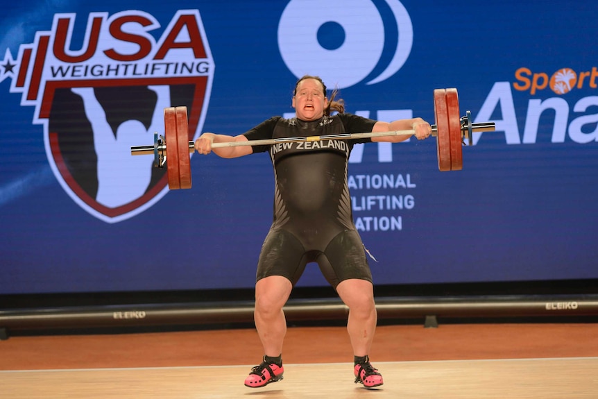 Laurel Hubbard heaves the bar upwards during a weightlifting competition.