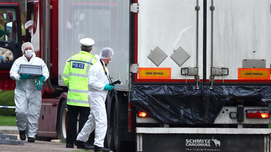 Police and forensic officers investigate around the truck, taking pictures and samples.