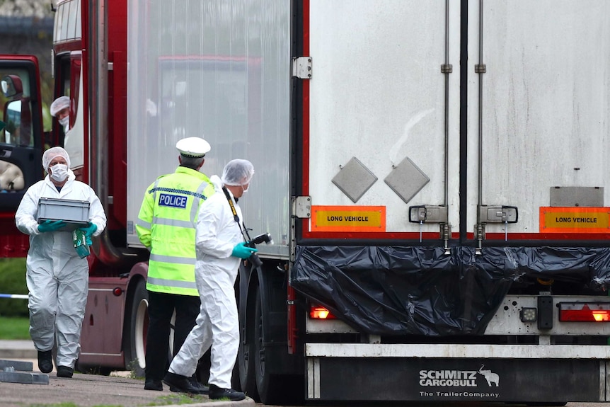 Police and forensic officers investigate around the truck, taking pictures and samples.