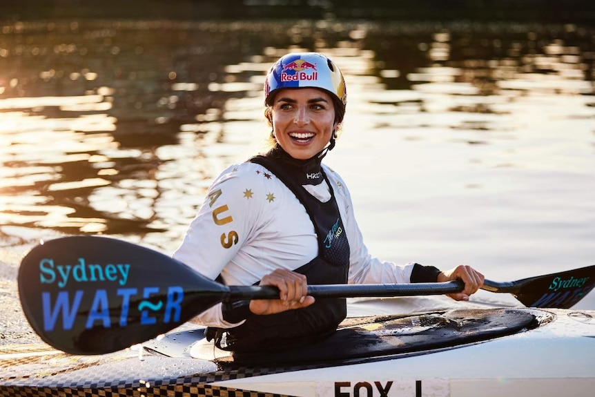Jessica Fox in a canoe on water holding a paddle