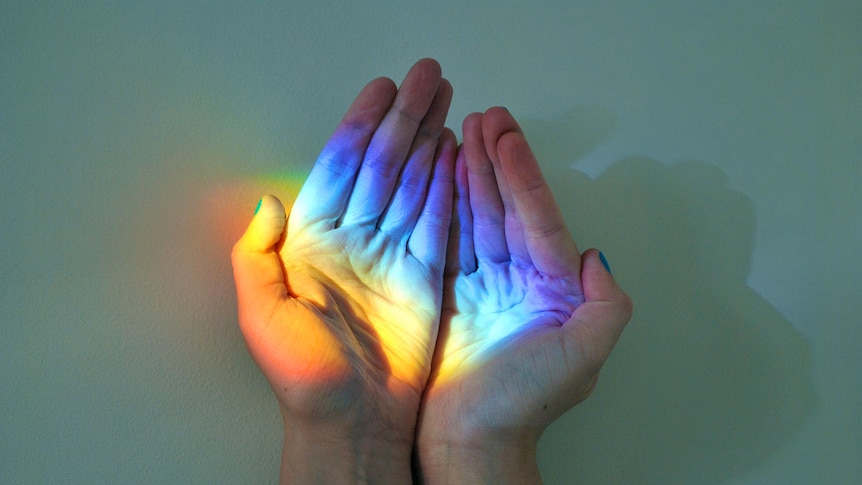 Hands cupping a refraction show the full colour spectrum of light