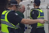 Ian Jamieson (centre) is escorted into court by two police officers.