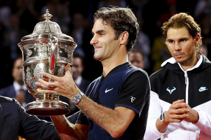 Roger Federer lifts the Basel trophy in front of Rafael Nadal