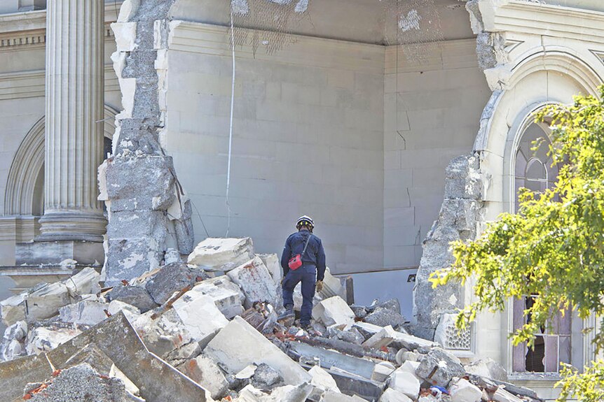 A rescue worker looks through the rubble of the Cathedral of Blessed Sacrament.