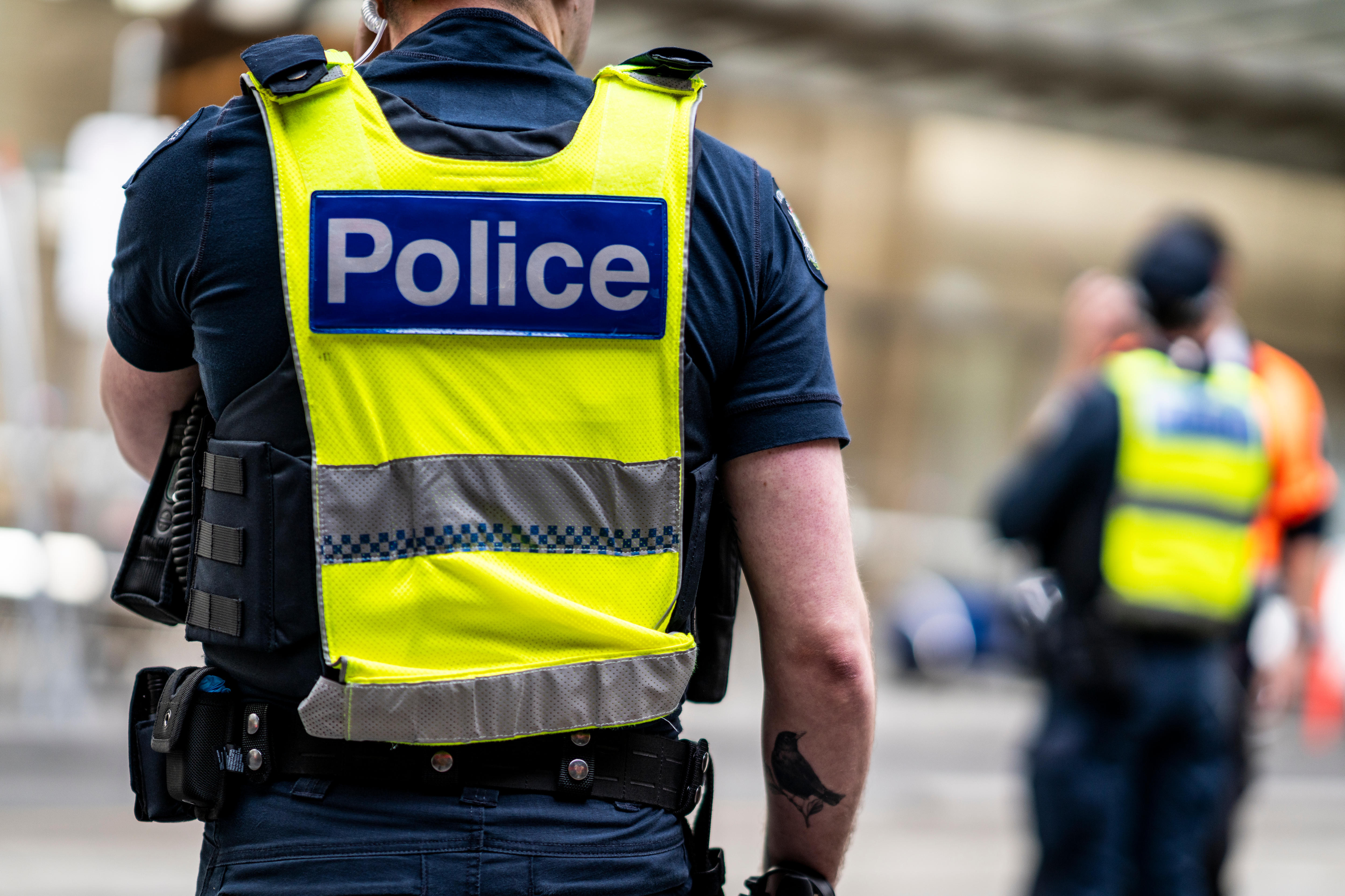 Victoria Police officers stand on the street in Melbourne.