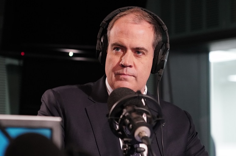 ABC managing director David Anderson sits in front of a microphone in a radio studio wearing headphones.