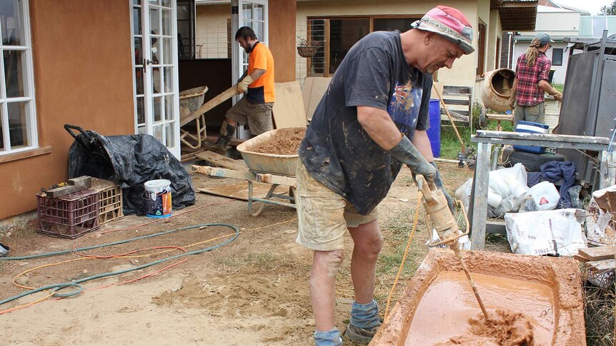 Peter Bertuleit mixing clay for an earth floor in a new house in the Bega eco-neighbourhood