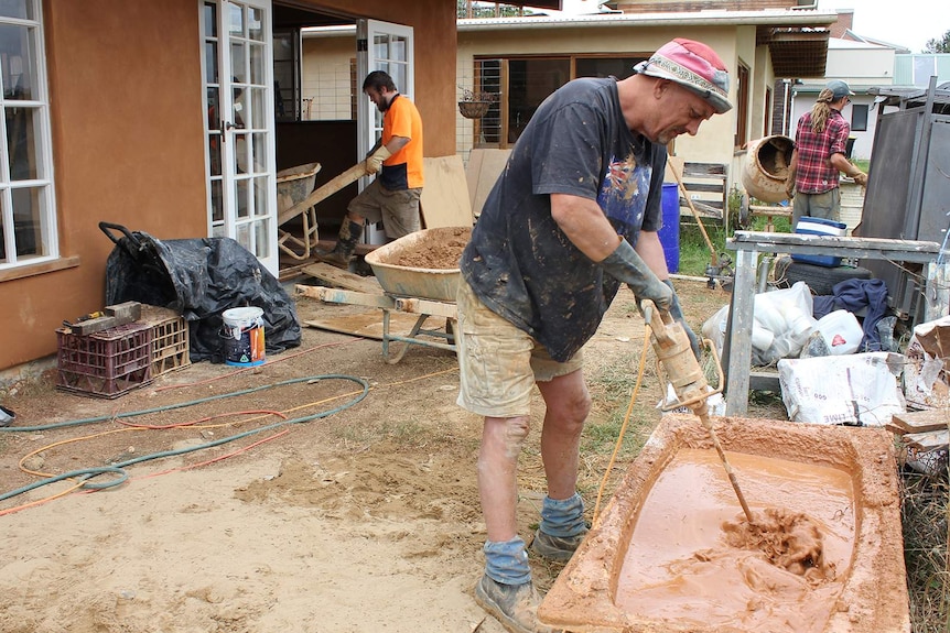 Peter Bertuleit mixing clay for an earth floor in a new house in the Bega eco-neighbourhood