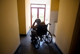 An elderly women rests on her wheel chair.