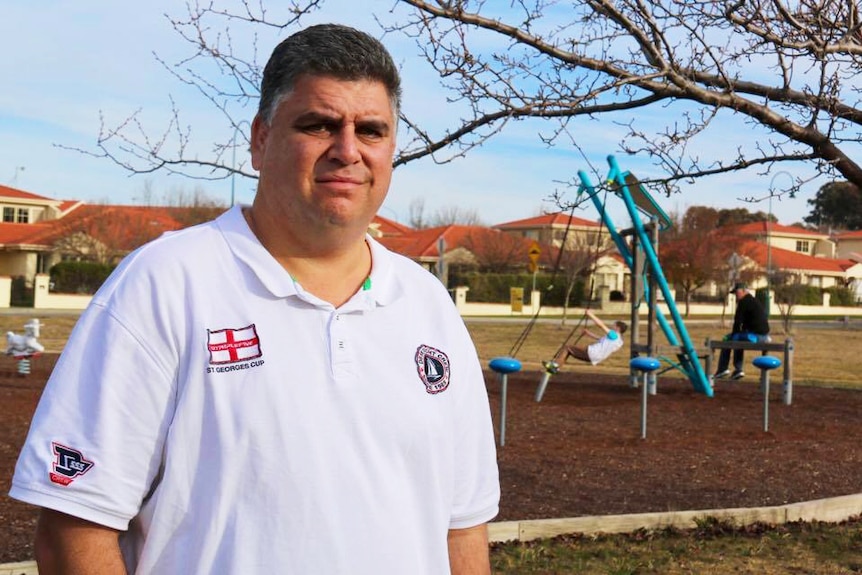 A man stands, looking concerned in front of a playground in Canberra.