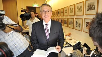 Treasurer Wayne Swan is surrounded by the media while in the budget lockup (Mark Graham/AAP)