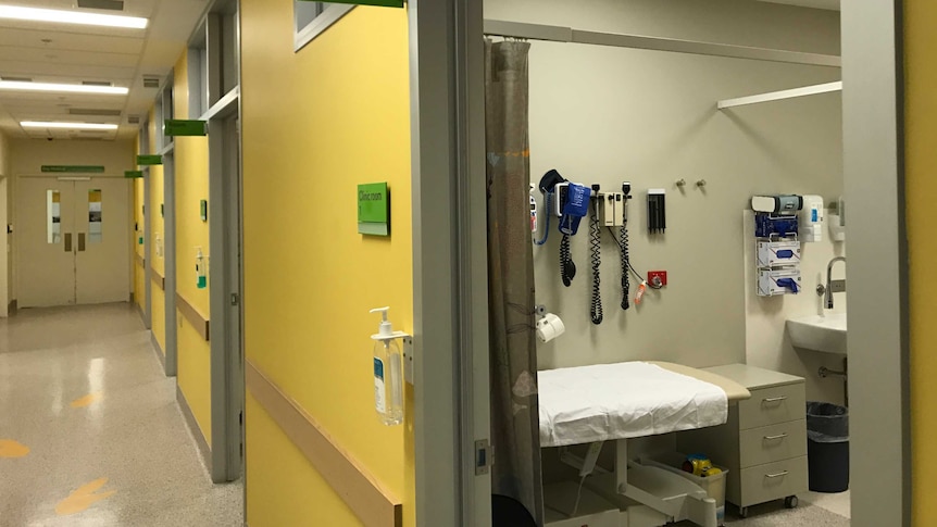 An empty hospital corridor and treatment room.