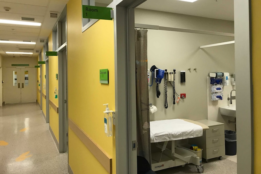 An empty hospital corridor and treatment room.