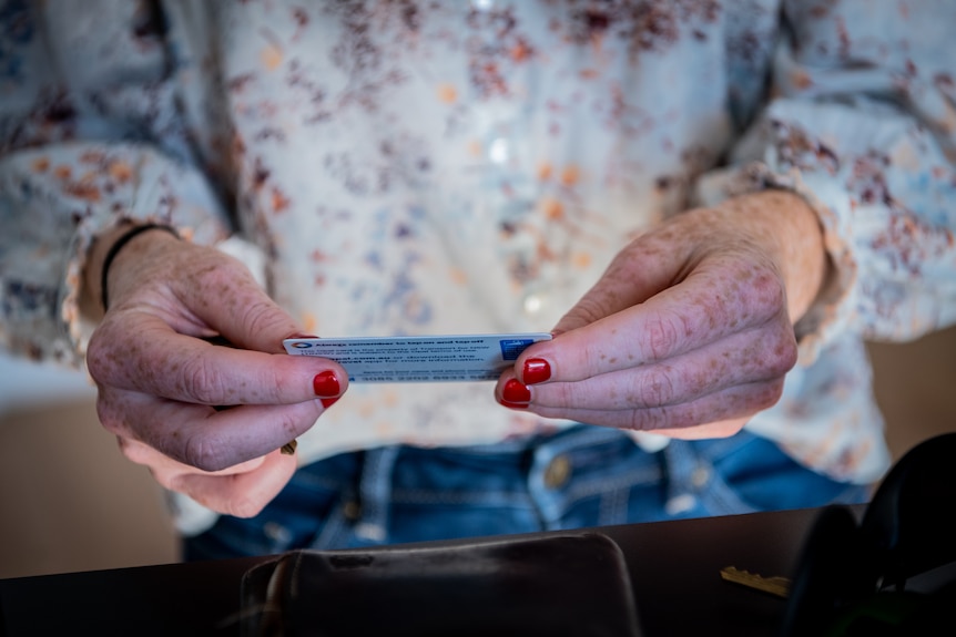 Close up of a woman's hands holding an Opal travel card