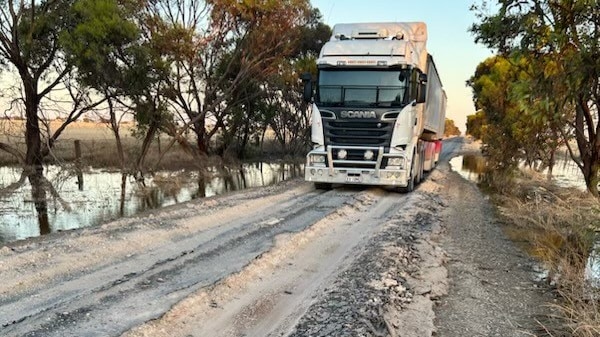 A truck drives along a clearly eroded road.