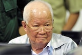 An edlerly Khieu Samphan wearing glasses with thin white hair