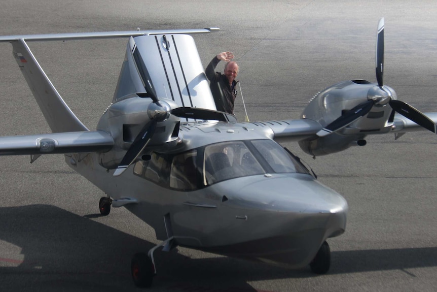 Australian pilot Michael Smith waves from the back of his sea plane which touched down a century after the Great Air Race