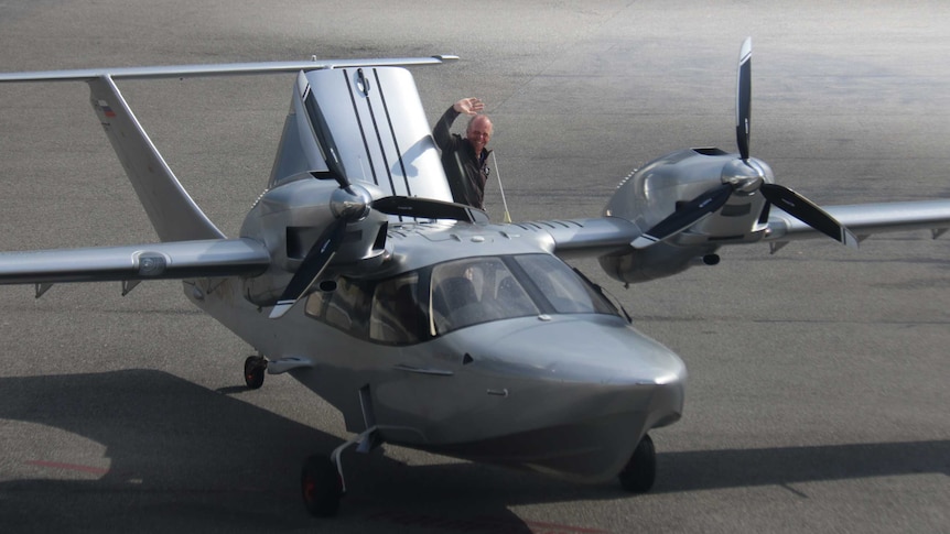 Australian pilot Michael Smith waves from the back of his sea plane which touched down a century after the Great Air Race