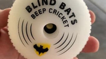 White ball with writing that says Blind Bats beep cricket